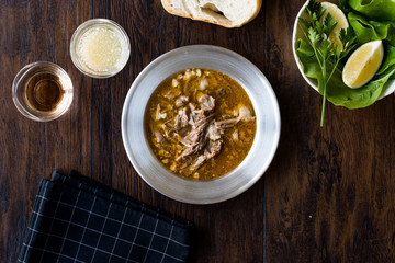 Turkish Soup Beyran with Lamb Meat, Rice, Chopped Garlic and Vinegar Sauce Served with Salad.