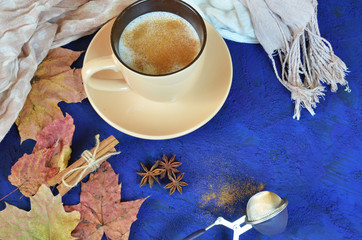 Autumn cappuccino composition. coffee cup top view with foam, cloves, cinnamon, autumn fallen...