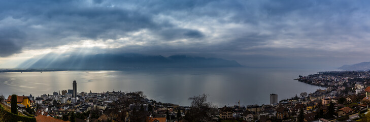 Panorama view of Montreux during dramatic stormy clouds weather with sun rays, Swiss Alps, Geneva  Lake on Lavaux region, Canton Vaud, Switzerland, Europe.