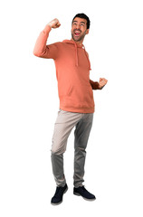 Full body of  Man in a pink sweatshirt celebrating a victory in winner position on isolated white background