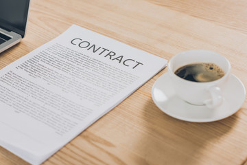 contract and cup of coffee on wooden table in office