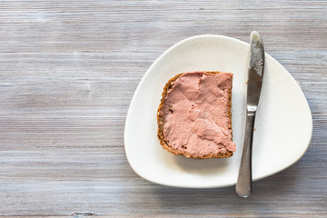 sandwich with pate and knife on white plate