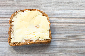 sandwich with butter on gray wooden board