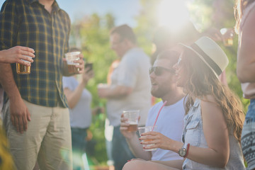 Obraz premium Couple sitting and drinking alcohol at outdoor party 
