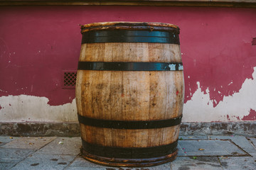an oak barrel with wine, against the background of the old wrapped wall
