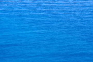 Aerial view of the clear blue sea surface on a bright sunny day.