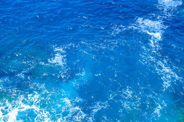 Aerial view of the clear blue sea surface on a bright sunny day.