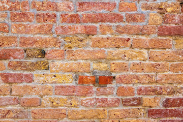 A vintage brick wall of a historic building on a sunny day.