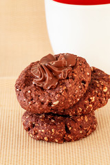 Chocolate oats cookies with chocolate nuts spread. Beige background. Selective focus.