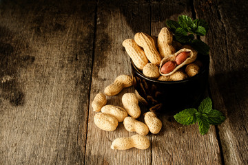 Still life peanut open shell to show seed in side on the wooden with glasses and book.