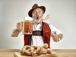 Germany, Bavaria, Upper Bavaria. The senior happy smiling man with beer dressed in traditional...