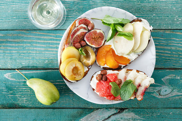 Fruit snacks wine Plate various fruit bruschetta glass white wine top view