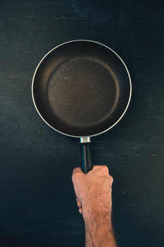 Hand holding frying pan skillet top view