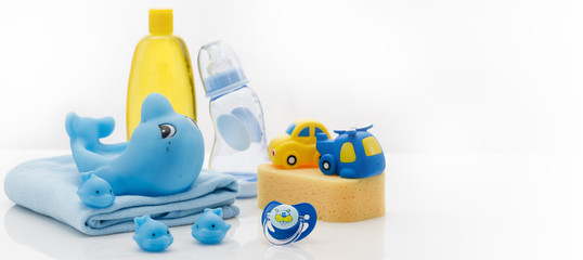 Still life with baby hygiene and bath items, shampoo bottle, essential oil, baby soap, towel, pacifier, rubber toy, shower puff. Copy space for your text