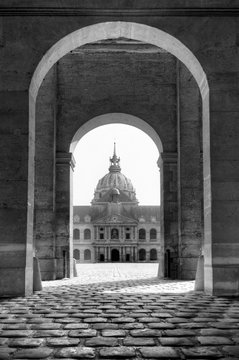 Fototapeta The golden dome of Les Invalides seen through the gate in Paris, France, in black and white  