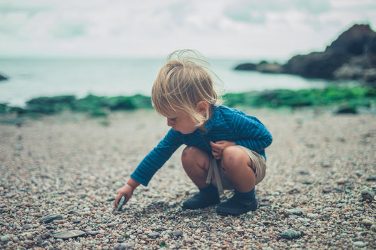 Toddler playing with stones on the beach