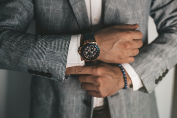 Fototapeta Businessman luxury style. Men style.closeup fashion image of luxury watch on wrist of man.body detail of a business man.Man's hand in a grey shirt with cufflinks in a pants pocket closeup. Toned obraz