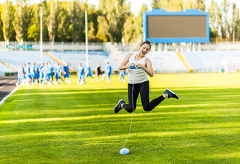 Obraz premium Woman athlete knitting a sweater on a football field