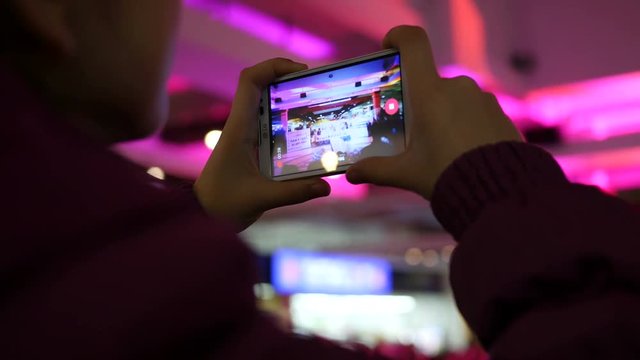 Spectator hands holding shooting video via smartphone of a concert performance