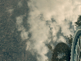 the reflection of the sky in the puddle and the wheel/background holiday