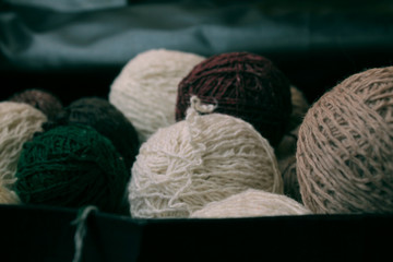 skeins of woolen yarn in pastel shades in a wooden background/felted wool bird