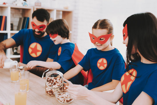 Young Family In Superhero Suits. Dinner Concept.