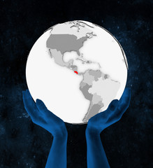 Costa Rica on white globe in hands