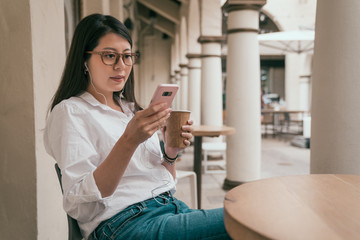 Obraz na płótnie Canvas woman wearing earphone and texting on phone