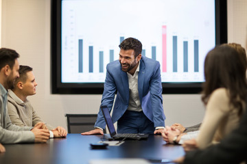 Young attractive businessman showing presentation to his colleagues