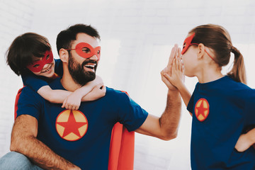 Father And Kids In Superhero Suits. High Five.