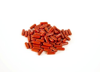 Medicine. Pharmacy theme. Red Isolated Drug Pills or Capsules on white background surface. Closeup. Selective focus