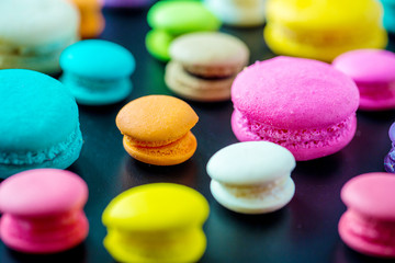 Obraz na płótnie Canvas Top view colorful macarons dessert with vintage pastel tones. Colorful french macarons background,Different colorful macaroons background.Tasty sweet color macaron,Bakery concept.Selective focus.