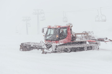 Fototapeta na wymiar Snowcat preparing a slope in high mountains at skiing resort