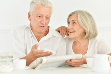 Close-up portrait of a  senior couple with newspaper