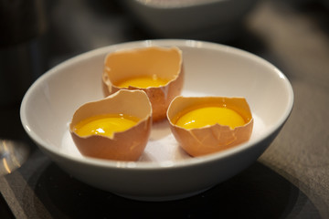 Open chicken eggs inside a boll ready to cook.