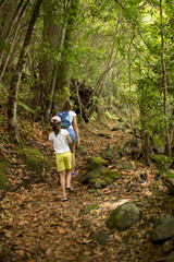 Mother and daughter walking through a forest