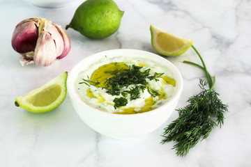 Freshly prepared tzatziki sauce, on white marble
