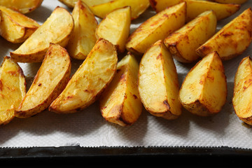 Freshly baked potato pieces on baking tray