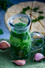 Moldovan sauce "Husband" from parsley, broth, garlic in a glass jug, selective focus