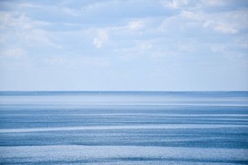 Distant sailboats in calm blue water
