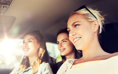 Obraz premium summer vacation, holidays, travel, road trip and people concept - happy teenage girls or young women driving in car