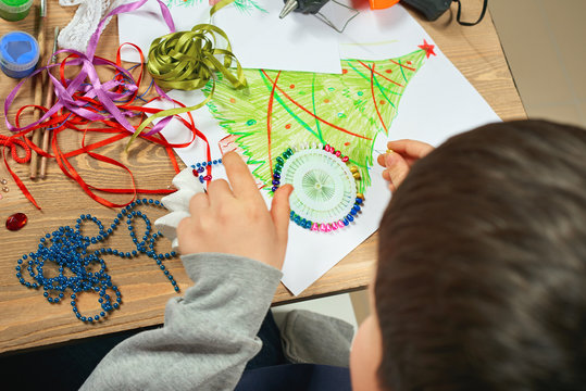 Childrens making decorations for new year holiday. Painting watercolors. Top view. Artwork workplace with creative accessories.