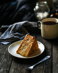 cake a piece, with cream on a white plate. Top view rosemary. food background