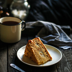 cake a piece, with cream on a white plate. Top view rosemary. food background