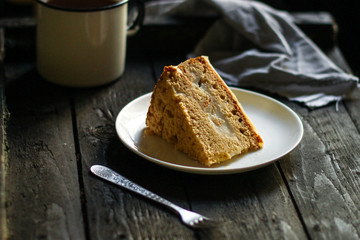 cake a piece, with cream on a white plate. Top view rosemary. food background