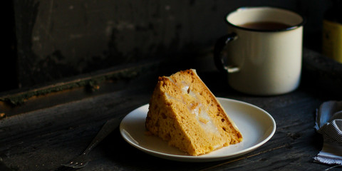cake a piece, with cream on a white plate. Top view rosemary. food background