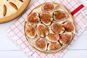 French Tart with Fruits Curd and Merengue Decorated with tasty Figs on White Wooden Background Pastry Tasty Homemade Tart and Pie with Plums Top View