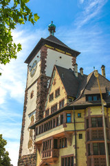 View on the ancient buildings with the Schwabentor clock tower in Freiburg im Breisgau, Germany on a sunny day.