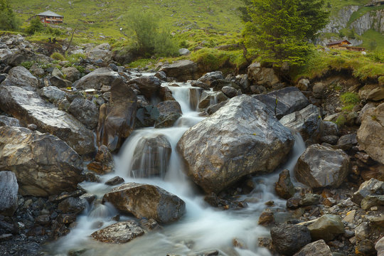Mountain brook with flowing water on the stones, long exposition