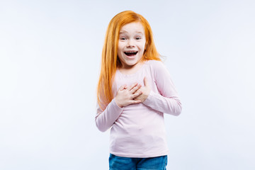 Positive emotions. Joyful emotional girl feeling very delighted while standing against blue...